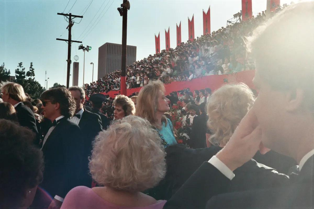 Arrivals on a red carpet lined with photographers.